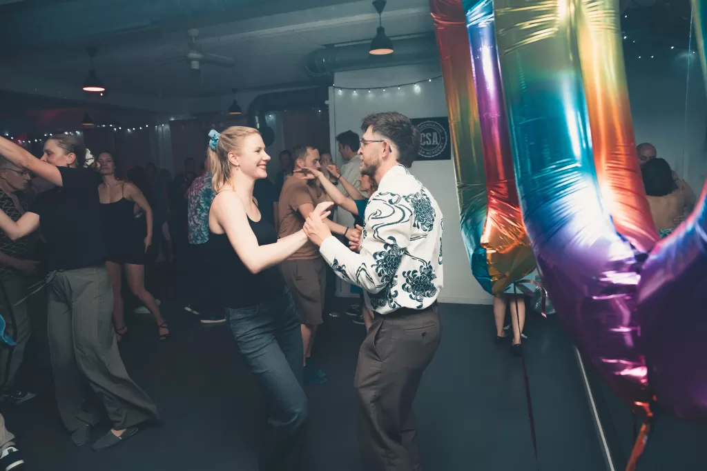 Salsapar danser foran 10-tals ballonen til Copenhagen Salsa Academys 10-års jubilæum