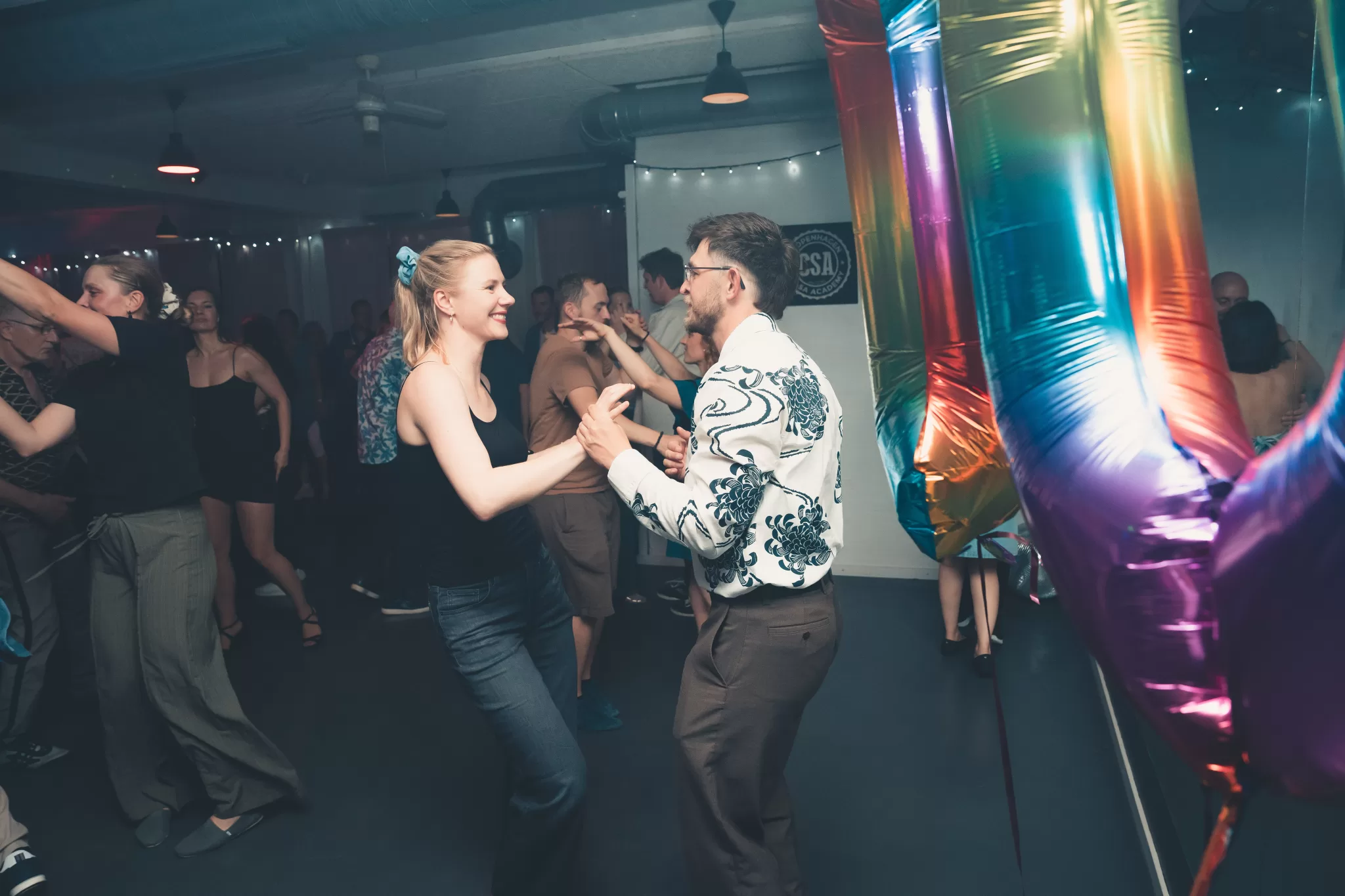 Salsapar danser foran 10-tals ballonen til Copenhagen Salsa Academys 10-års jubilæum